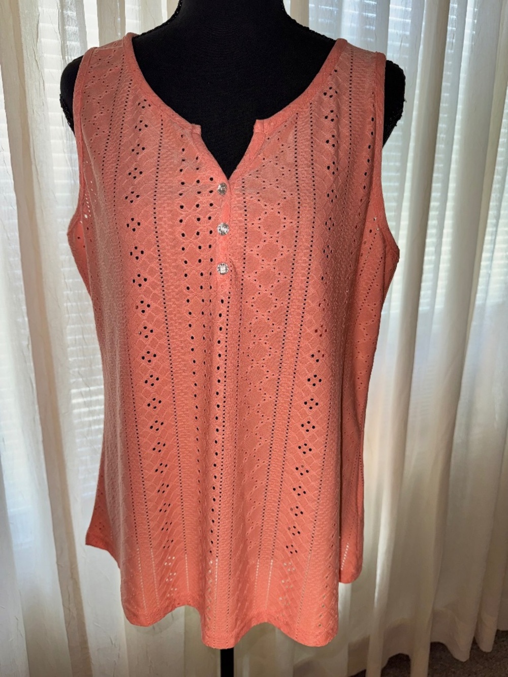 Woman's coral tank top with notched collar and shining buttons